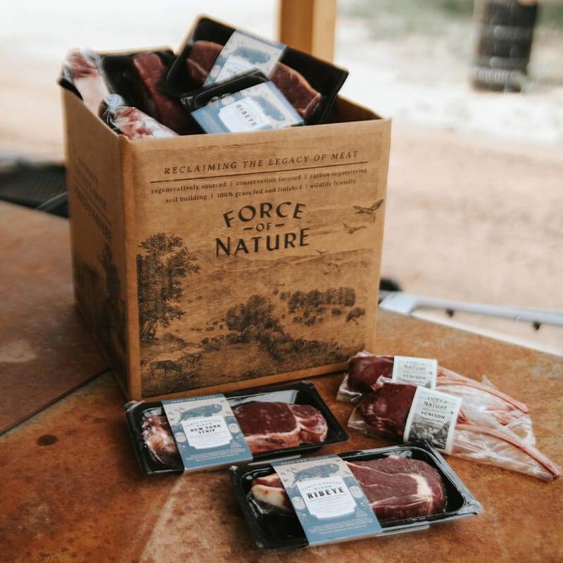 Product image of a cardboard box labeled "Force of Nature" with packages of plastic-wrapped steaks in front.